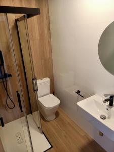 a bathroom with a toilet and a sink at Albergue La Huella in San Martín del Camino