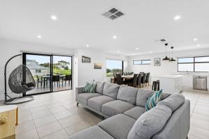 a living room with a gray couch and a kitchen at Flagstaff Lodge in Portarlington