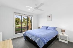a white bedroom with a bed and a window at Flagstaff Lodge in Portarlington