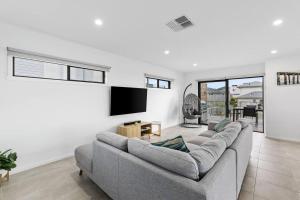 a living room with a couch and a flat screen tv at Flagstaff Lodge in Portarlington