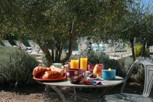 a table with a breakfast of bread and orange juice at Mas de l'Estello B&B in Saint-Rémy-de-Provence
