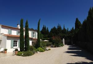 ein Haus mit Bäumen vor einer Einfahrt in der Unterkunft Mas de l'Estello B&B in Saint-Rémy-de-Provence