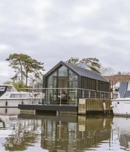 a tiny house on a boat on a body of water at Water Cabin With Water Sports Equipment and Bikes, Bath in Bristol