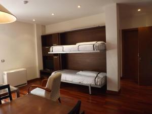 a room with two bunk beds and a table at Roca Nevada Suites in Villanúa