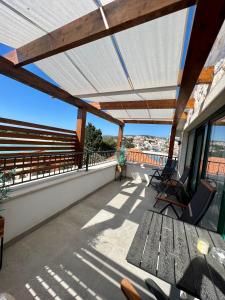 a patio with a wooden table and chairs on a roof at Luxury apartments Azalea Primošten in Primošten