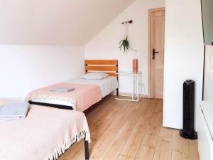 sypialnia z 2 łóżkami i drewnianą podłogą w obiekcie Salve Regina w mieście Sandomierz