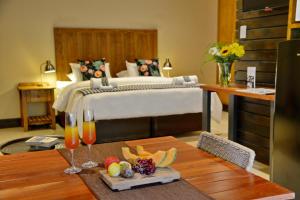 a bedroom with a bed and a table with drinks at La Perle in Ballito