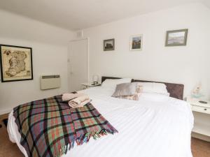 a bedroom with a white bed with towels on it at 12 Kenmore Cottages in Oban