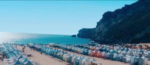 a beach with a bunch of umbrellas and the ocean at Casa da Carochinha in Nazaré