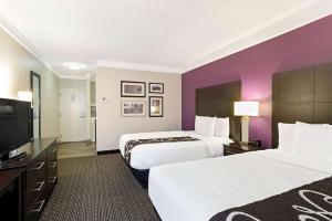 a hotel room with two beds and a flat screen tv at La Quinta by Wyndham Boston-Andover in Andover