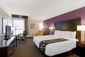 a hotel room with a large bed and a desk at La Quinta by Wyndham Boston-Andover in Andover