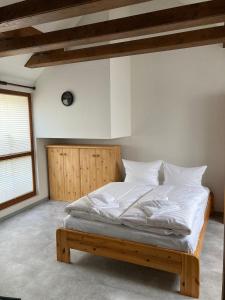 a bed with white sheets and pillows in a room at Ferienwohnung Am Tränketor in Blankenburg