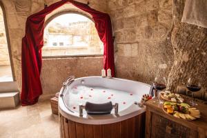 una vasca da bagno in una stanza con finestra di Kayata Cave Suites Special Class a Ürgüp
