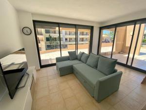 a living room with a couch and a clock at Janelas do Oceano - Casa de Ferias T3 Vilamoura in Vilamoura