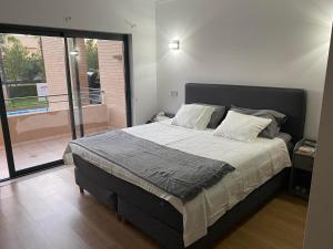 a bedroom with a large bed and a balcony at Janelas do Oceano - Casa de Ferias T3 Vilamoura in Vilamoura +23 photos