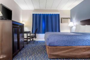 a hotel room with a bed and a flat screen tv at Econo Lodge in Hicksville