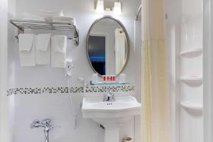 a white bathroom with a sink and a mirror at Econo Lodge Hicksville in Hicksville
