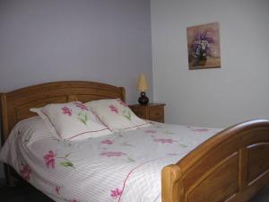 Gîte de Romagers في La Chaze-de-Peyre: غرفة نوم مع سرير مع زهور وردية عليه