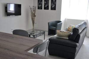 una sala de estar con un sofá y una mesa en Gîte de Romagers, en La Chaze-de-Peyre