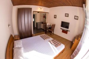 ein kleines Schlafzimmer mit einem Bett und einem TV in der Unterkunft Apartments Kole in Rafailovici