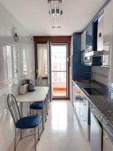 a kitchen with a table and chairs in a room at Apt Las Olas Cotolino con parking a 2' de la playa in Castro-Urdiales