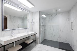 a white bathroom with a sink and a shower at Riu Plaza The Gresham Dublin in Dublin