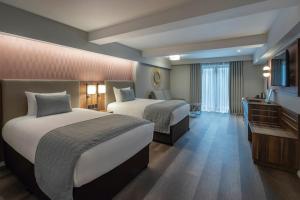 a hotel room with two beds and a television at Riu Plaza The Gresham Dublin in Dublin