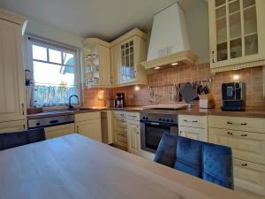 a kitchen with white cabinets and a table and a window at BooHouse in Zingst