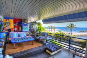 シッチェスにあるWATER FRONT DUPLEX by Hello Homes Sitgesのビーチの景色を望むバルコニー付きの客室です。