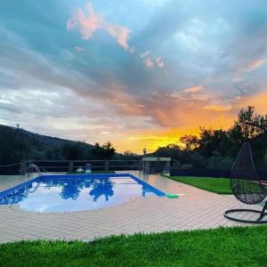a large swimming pool with a sunset in the background at Centro estivo Il Piccolo Paradiso in Sonnino