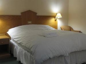 un grande letto bianco in una stanza d'albergo di Hazelwood House a Bridgend