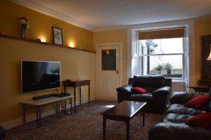 un soggiorno con divano e TV a schermo piatto di West End Apartment a Edimburgo