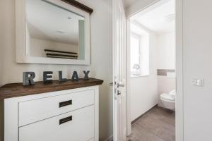 uma casa de banho com um toucador branco e um espelho. em Haus Deichkieker Apartment 2 1 Grothus em Büsum