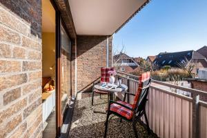 d'une terrasse avec une table et des chaises sur un balcon. dans l'établissement Haus Am Anker Wohnung 4, à Büsum