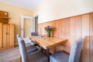- une salle à manger avec une table et des chaises en bois dans l'établissement Haus Am Anker Wohnung 4, à Büsum