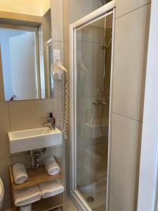 ein Bad mit einer Dusche und einem Waschbecken in der Unterkunft Twix rooms in Ljubljana