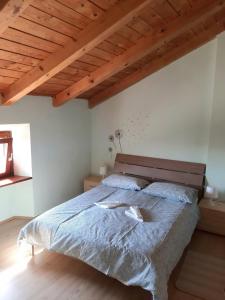 ein Schlafzimmer mit einem großen Bett und einer Holzdecke in der Unterkunft Casa Girasole in Buje