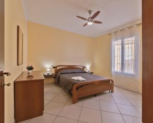 une chambre avec un lit et un ventilateur de plafond dans l'établissement Casa Conca Azzurra, à Costarainera