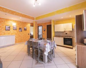 une cuisine avec une table et des chaises dans une pièce dans l'établissement Casa Conca Azzurra, à Costarainera