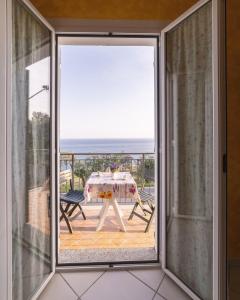 une porte coulissante en verre menant à une terrasse avec une table. dans l'établissement Casa Conca Azzurra, à Costarainera 9 autres photos