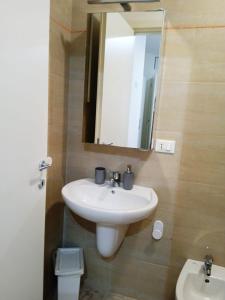 a bathroom with a sink and a mirror and a toilet at Casa vacanze Sabin in Polignano a Mare