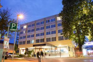 um grande edifício com pessoas andando na frente dele em PARKHOTEL Krems em Krems an der Donau