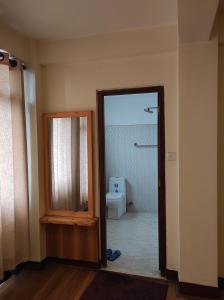 a bathroom with a shower and a toilet and a mirror at Awale House in Pātan