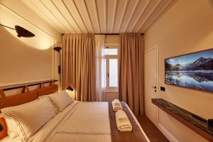 a bedroom with a bed and a tv on a wall at Regno Di Morea in Nafplio