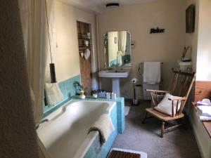 ein Badezimmer mit einer Badewanne und einem Waschbecken in der Unterkunft The Hollow Bed and Breakfast in Great Longstone