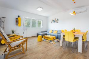 salon z kanapą, stołem i żółtymi krzesłami w obiekcie Sunny Sunny Peroj w mieście Vodnjan