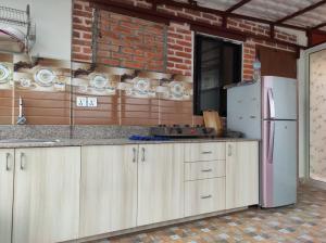 a kitchen with wooden cabinets and a refrigerator at Awale House in Pātan