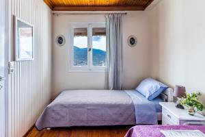 a bedroom with a bed and a window at VASIA HOUSE in Skopelos Town +22 photos