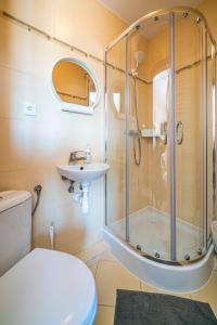 uma casa de banho com um chuveiro, um WC e um lavatório. em Pokoje Gościnne Dominika em Jastarnia