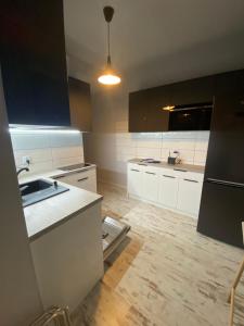 una cocina con armarios blancos y fregadero. en Apartament nad jeziorem Białym, en Augustów